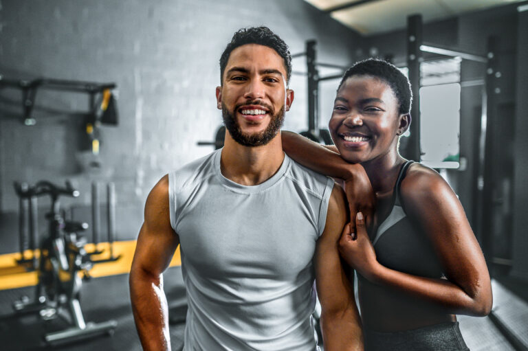 Portrait Of Cheerful Multiracial Young Couple In Gym